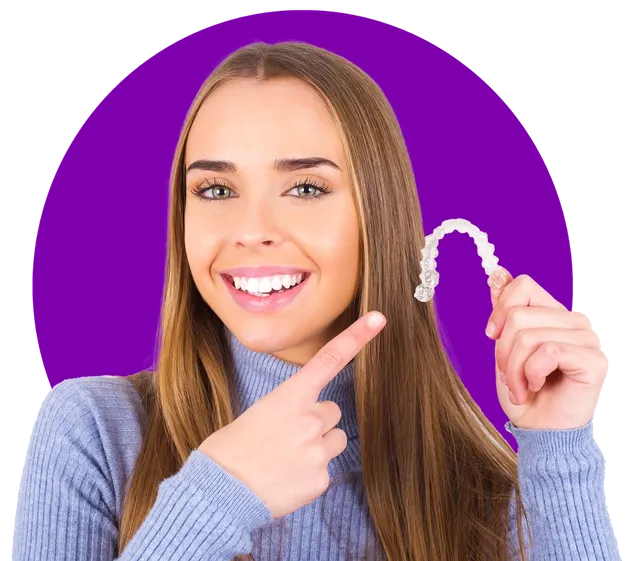 Smiling patient holding Invisalign clear aligner at Family Braces Calgary