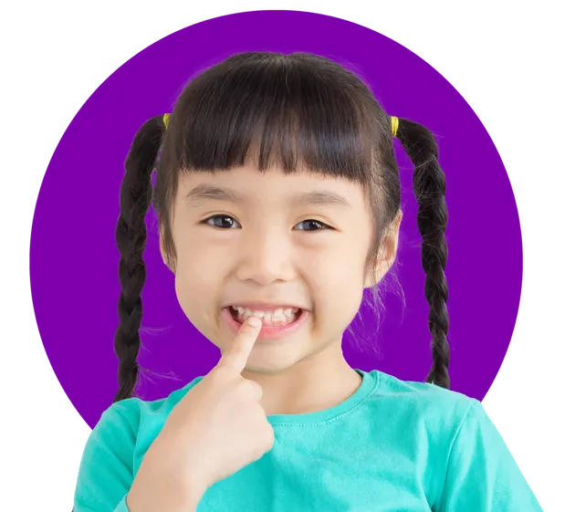 Young girl pointing at her teeth for early orthodontic treatment at Family Braces Calgary